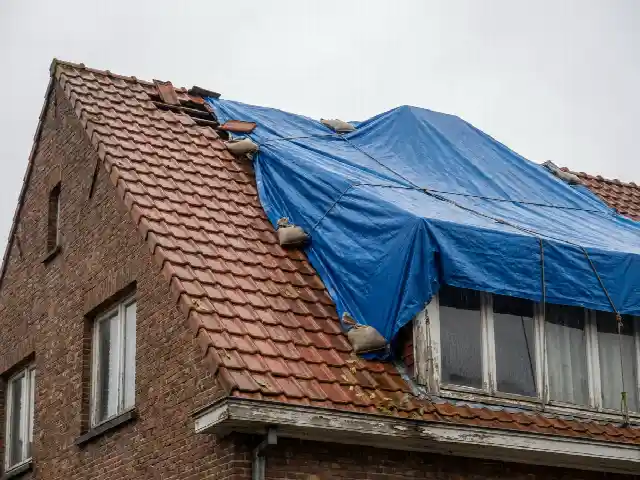Bâche d'urgence tendue sur un toit endommagé par une tempête